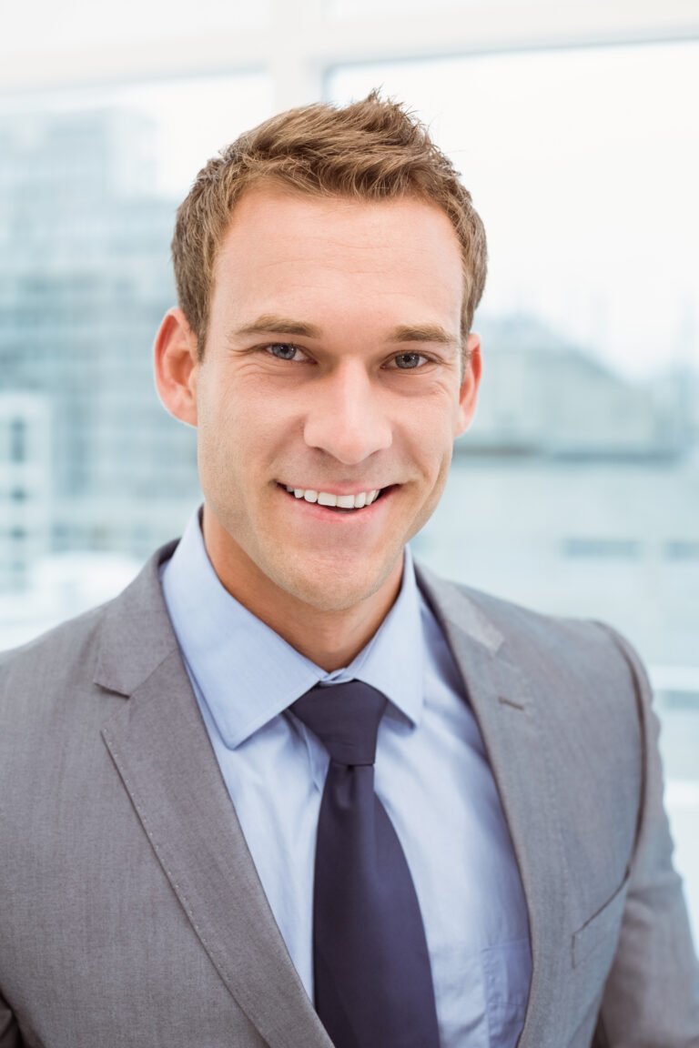 Close up portrait of smart young businessman in suit at office